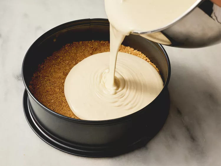 Cheesecake filling being poured into the pan